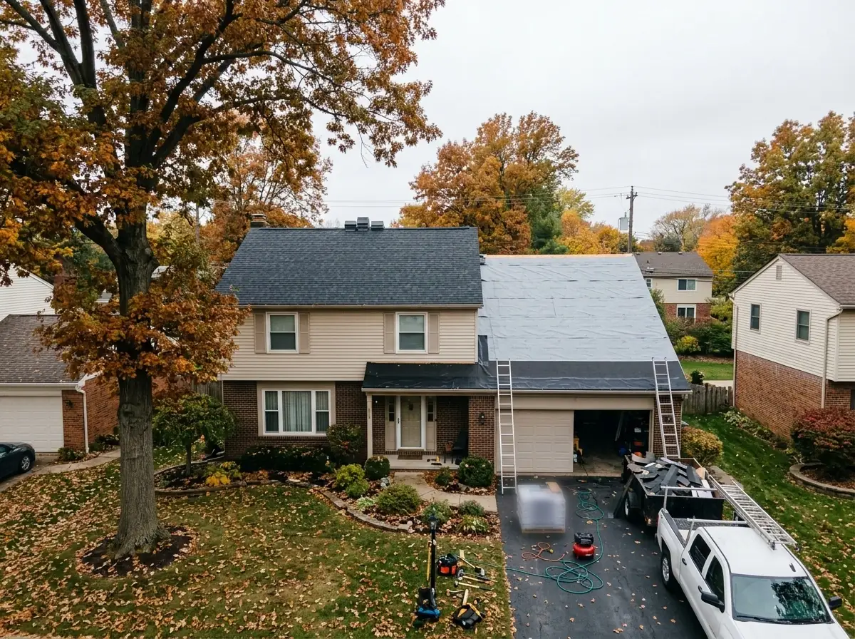 Two-story brick and vinyl colonial with half the main roof finished in new charcoal shingles and the other half covered in gray synthetic underlayment